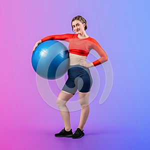 Full body length gaiety shot athletic and sporty young woman with fitness ball