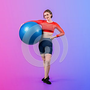 Full body length gaiety shot athletic and sporty young woman with fitness ball