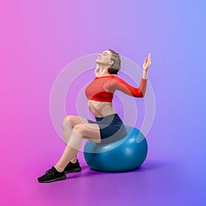 Full body length gaiety shot athletic and sporty young woman with fitness ball