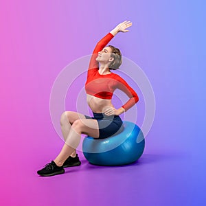 Full body length gaiety shot athletic and sporty young woman with fitness ball