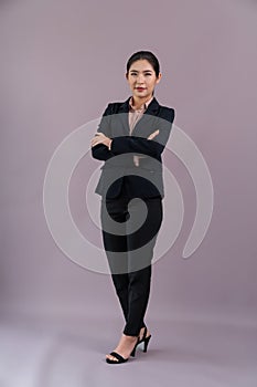 Confident young businesswoman stands on isolated background. Enthusiastic