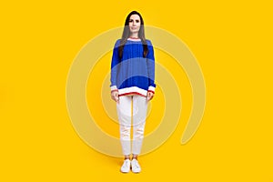 Full body length photo of young woman brunette hair latin in blue knitted sweater with white pants isolated on yellow