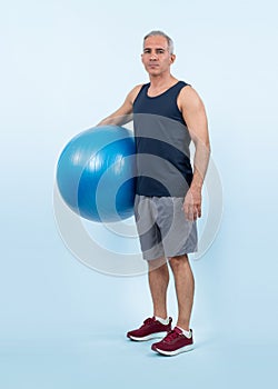 Full body length shot athletic and sporty senior man with fit ball. Clout