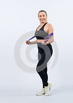 Full body length shot athletic sporty senior woman with resistance band. Clout