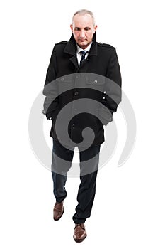 Full body of middle age business man walking wearing overcoat