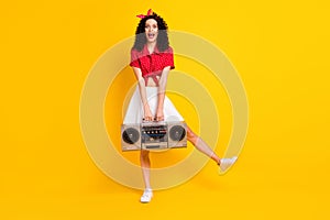 Full body photo of amazed funky young woman hold boom box music isolated on shine yellow color background