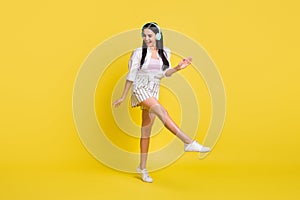 Full body photo of attractive funky woman dance dreamy wear headset isolated on yellow color background