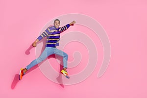 Full body photo of attractive young man jumping flying superhero dressed stylish violet striped clothes isolated on pink