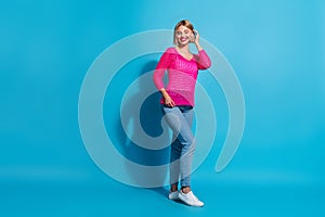 Full body photo of attractive young woman posing defile model dressed stylish pink knitwear clothes isolated on blue photo