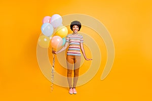 Full body photo of charming cheerful brunette curly hair dark skin teen girl hold many colorful baloons she got on