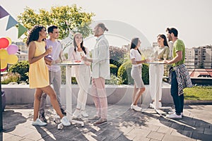 Full body photo of crowd of fellows standing around table hold drink glass gathering top roof cafe outdoors