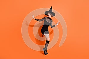 Full body photo of cute girl look frighten empty space escape dressed trendy black halloween garment isolated on orange
