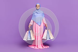 Full body photo of funny millennial lady do shopping wearing blue arabic head wrap muslim pink dress isolated over