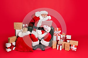 Full body photo of impressed santa claus in hat with eyewear eyeglasses read noel news on his laptop feel stupor