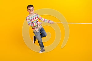 Full body photo of kid boy have weekend free time play active sport game tug war isolated on bright color background