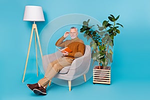 Full body photo of man sit chair read information knowledge paper book isolated blue color background