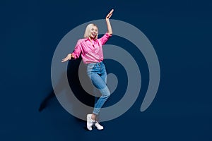 Full body photo of optimistic woman wear stylish shirt denim trousers dancing on discotheque isolated on dark blue color