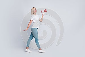 Full body photo of positive adorable girl wear white t-shirt jeans holding megaphone announcing sale isolated on gray