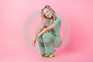 Full body photo of pretty young girl squating posing defile model dressed stylish green print outfit isolated on pink