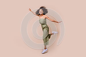 Full body photo of pretty young woman wavy hair jump spread hands plane pose dressed stylish khaki look isolated on