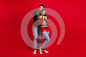 Full body photo of two idyllic peaceful partners cuddle empty space ad festive time  on red color background