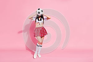 Full body photo of unknown lady soccer ball hands hiding face incognito wear red short skirt white top isolated pink