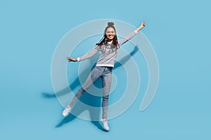 Full body photo of young afro girl happy positive smile jump catch parasol isolated over blue color background