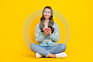 Full body photo of young attractive lady sitting relaxed hold cup of aromatic coffee look empty enjoy mornings isolated