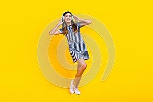 Full body photo of young chinese lady touch wireless headphones rest listen itunes music have fun  on yellow photo