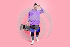 Full body photo of young cool guy ego party hold boombox music lover isolated over pink color background