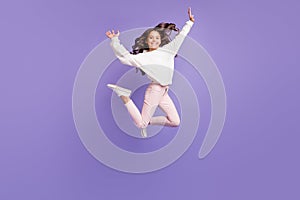 Full body photo of young crazy girl have fun enjoy happy smile jump up trampoline isolated over violet color background