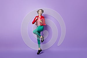 Full body photo of young excited girl happy positive smile have fun jump up isolated over violet color background