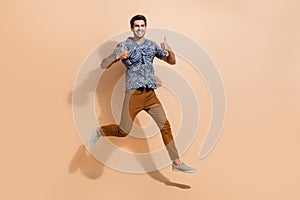 Full body photo of young funky businessman jump carefree and showing thumbs up approve your candidature isolated on