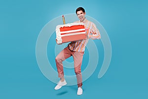 Full body photo of young guy happy positive smile hold cake sugar sweet birthday isolated over blue color background photo