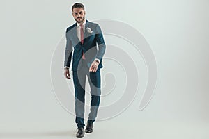 Full body picture of elegant businessman in suit walking