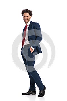 Full body picture of happy young businessman posing with hands in pockets