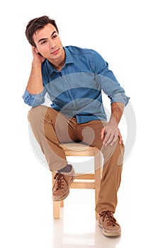 Full body picture of a seated casual man dreaming