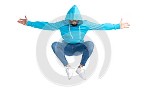 Young bearded man covering face while jumping in the air