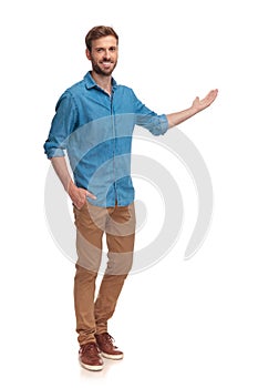 Full body picture of a young casual man presenting photo