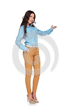 Full body picture of a young casual woman presenting