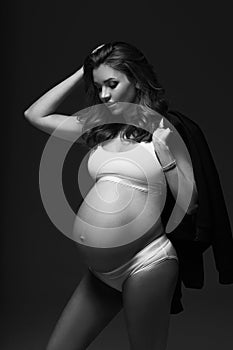 Pregnant female model in sports underwear standing and posing