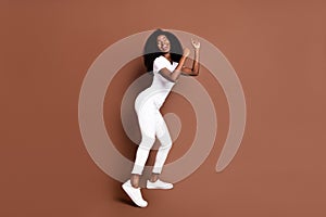 Full body portrait of charming dark skin girl closed eyes partying have good mood isolated on brown color background