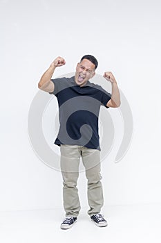 Full body portrait of an ecstatic and rowdy middle-aged Asian man rejoicing and hollering with raised fists, isolated on a white