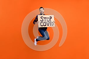 Full body portrait of excited crazy man open mouth smile hands hold paper banner isolated on orange color background