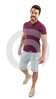 Full body portrait of friendly man walking. Beautiful and bearded person. He is wearing a magenta polo shirt and shorts jeans..