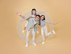 Full body portrait happy asian family standing giving piggyback ride to daughter, sit on back isolated on color background