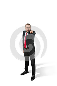 Full body portrait of happy businessman pointing to camera on white