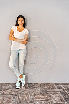 Full body portrait of happy smiling beautiful young woman, isolated over gray background.