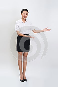 Full body portrait of happy smiling young beautiful business woman showing something or copyspase