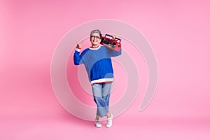 Full body portrait of nice aged lady hold boombox show heavy metal symbol wear blue sweater isolated on pink color